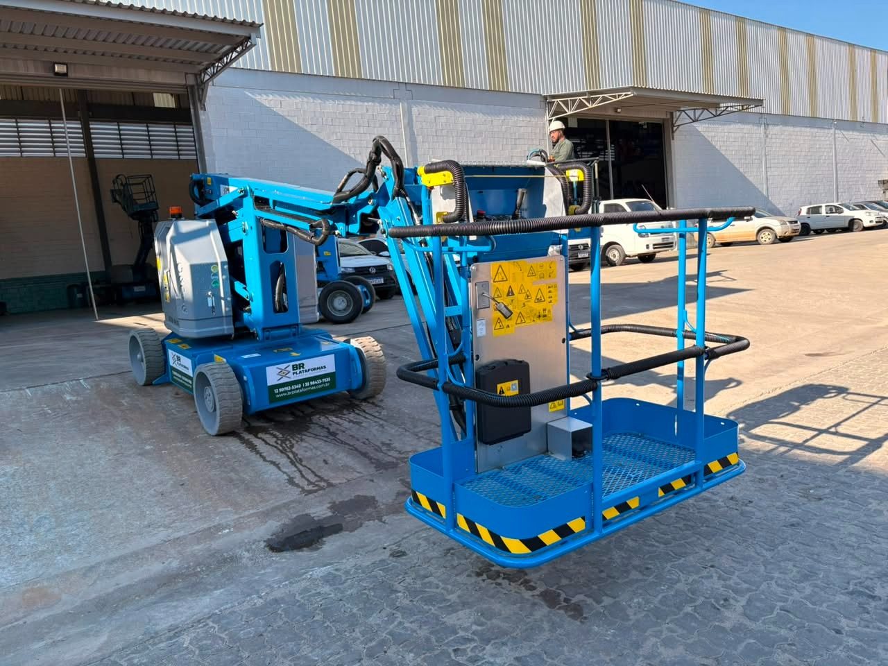 Plataforma articulada elétrica compacta com cesto em primeiro plano